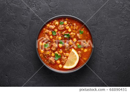 Moroccan Harira Soup in black bowl at dark slate table top Moroccan Harira Soup in black bowl at dark slate table top 68890431