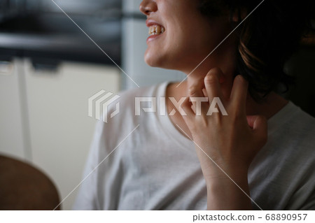 A woman scratching her neck 68890957