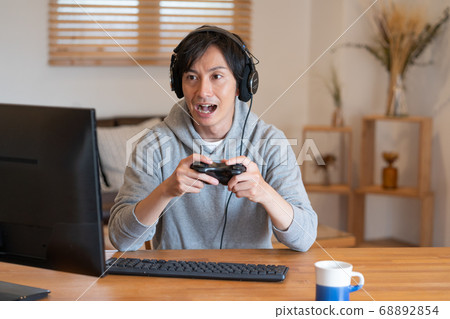 Young men playing online games 68892854