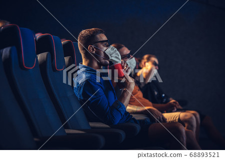 Cinema, movie theatre during quarantine. Coronavirus pandemic safety rules, social distance during movie watching Cinema, movie theatre during quarantine. Coronavirus pandemic safety rules, social distance during movie watching 68893521