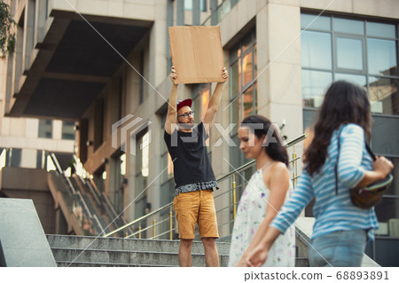 Dude with sign - man stands protesting things that annoy him 68893891