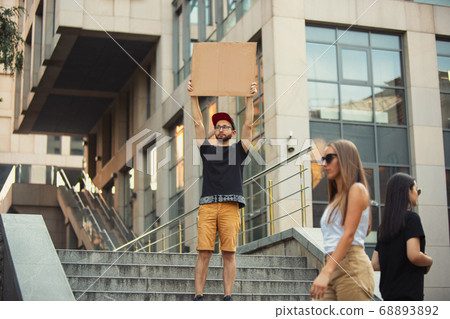 Dude with sign - man stands protesting things that annoy him 68893892