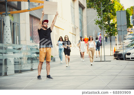 Dude with sign - man stands protesting things that annoy him 68893909