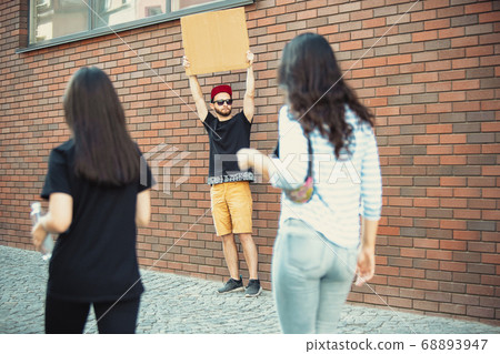 Dude with sign - man stands protesting things that annoy him 68893947