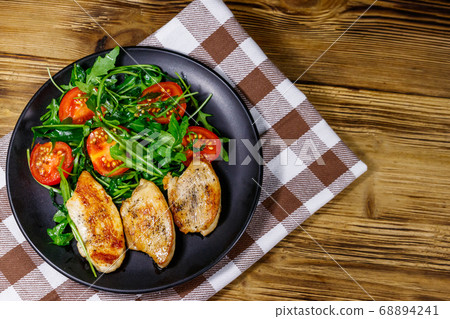 Fried chicken breast with salad of fresh arugula Fried chicken breast with salad of fresh arugula 68894241
