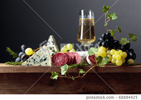 White wine and snacks on an old wooden table. 68894425