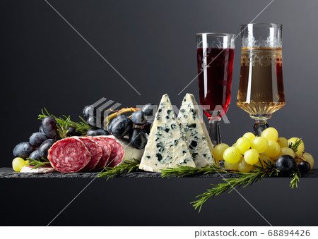 Red and white wine with snacks on a black 68894426