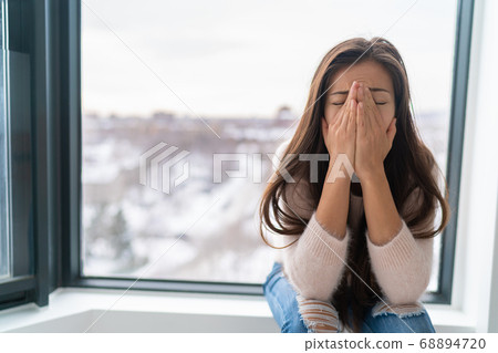 Anxiety winter depression woman having a panic attack and a hard time breathing. Home alone girl crying stressed depressed Anxiety winter depression woman having a panic attack and a hard time breathing. Home alone girl crying stressed depressed 68894720