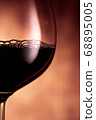 Goblet with red wine on glowing background 68895005