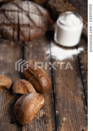 Rye buns and flour on table 68895009