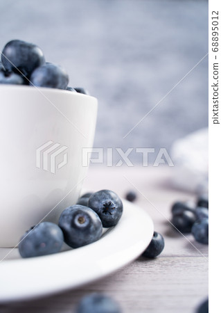 Ripe blueberries on plate and in bowl Ripe blueberries on plate and in bowl 68895012