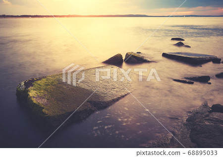 Rocks in water at sunset, Swinoujscie, Poland. Rocks in water at sunset, Swinoujscie, Poland. 68895033
