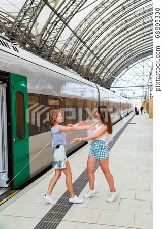 Happy meeting of two girlfriends near a modern 68895330