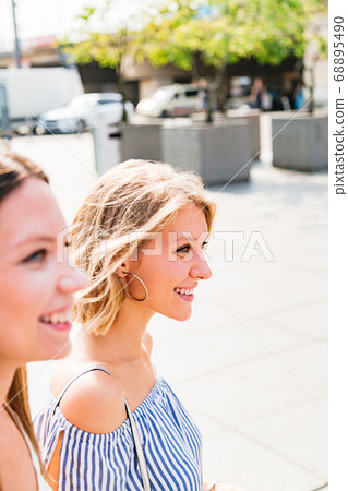 Two smiling girls walking on summer sunny day 68895490