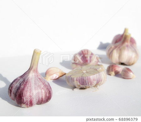 Whole garlic and cloves on a white background with space for text. Spicy food concept. Poster, menu. Whole garlic and cloves on a white background with space for text. Spicy food concept. Poster, menu. 68896379