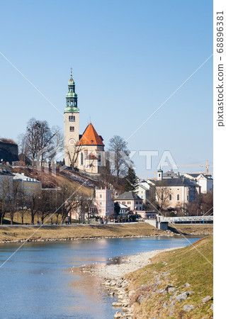 The view along the Salzach River in Salzburg, Austria. In the background can be seen the "Mullner Steg" Bridge and the the parish church Mulln, a Roman Catholic church. 68896381
