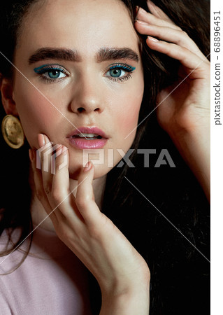Portrait of a beautiful girl with long curly hair, natural thick eyebrows. In a pink dress.Natural beauty. Portrait of a beautiful girl with long curly hair, natural thick eyebrows. In a pink dress.Natural beauty. 68896451