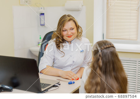 Woman pediatric neurologist talking to a girl in Woman pediatric neurologist talking to a girl in 68897584