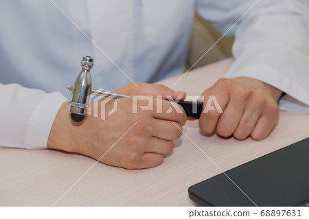 Male doctor neurologist with a hammer in his hands 68897631