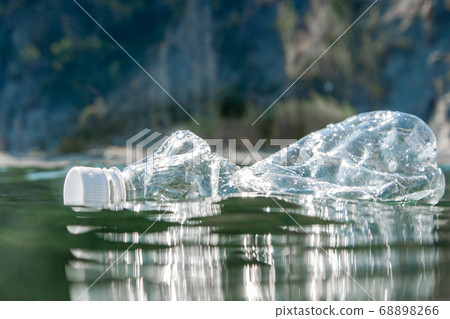 A plastic bottle floats on the water surface by the ocean. Ecology concept. A plastic bottle floats on the water surface by the ocean. Ecology concept. 68898266