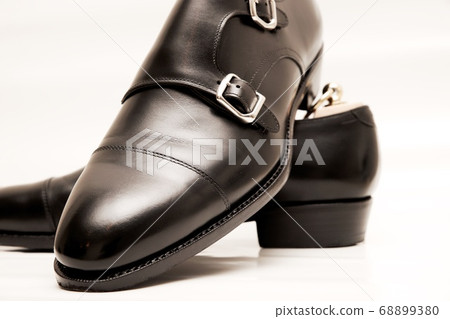 Black double monk strap leather shoes taken on white background 68899380