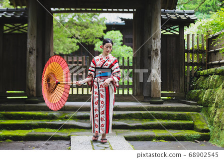 A woman with a yukata and a Japanese umbrella 68902545
