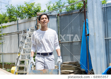 Young male worker working at a construction site 68905957