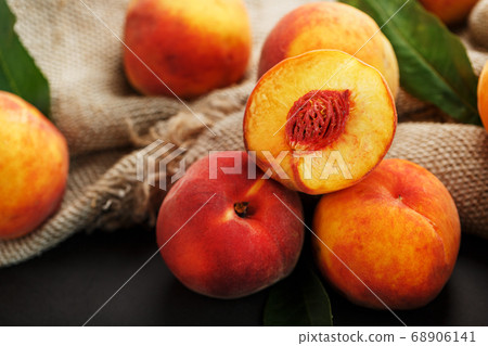 Peaches on a black background with burlap fabric Peaches on a black background with burlap fabric 68906141