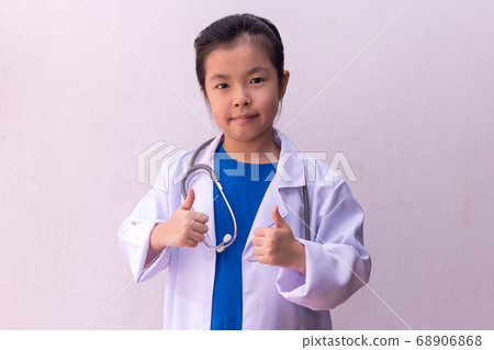 Asian girl playing doctor with stethoscope in Asian girl playing doctor with stethoscope in 68906868