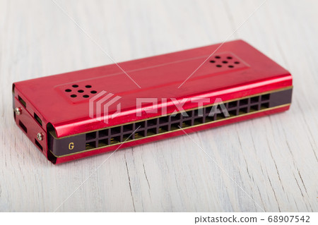 Harmonica on a wooden table 68907542
