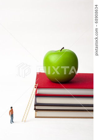Miniature man with book and apple 68908634