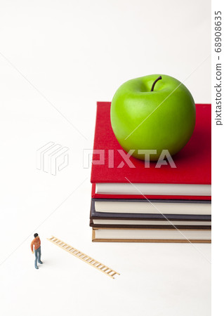 Miniature man with book and apple 68908635