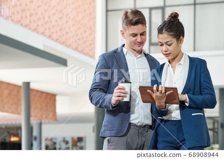 Business colleagues reading article 68908944