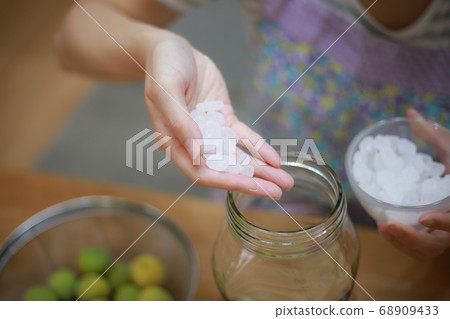 Woman making plum wine 68909433