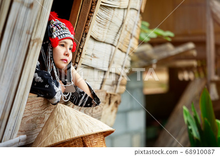 Local Asian woman call Hmong girl thinking at window of local wooden house Local Asian woman call Hmong girl thinking at window of local wooden house 68910087