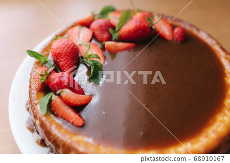 Tasty strawberry tart decorated with mint leaves on wooden table. Caramel glaze on top of tart. Vegan breakfast. Lactose and gluten free 68910167