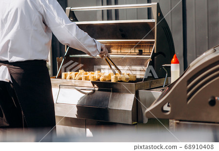 chef prepares corn charcoal grill outside party chef prepares corn charcoal grill outside party 68910408