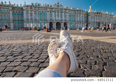 female legs in worn white macasinas on Palace female legs in worn white macasinas on Palace 68911511