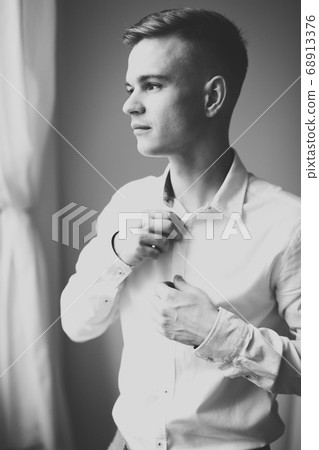 Grooms morning preparation. Handsome man getting dressed and preparing for the wedding 68913376