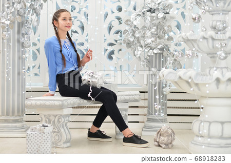 Cute girl sitting with gift in studio Cute girl sitting with gift in studio 68918283