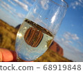 Uluru shines in a glass of champagne under a blue sky in Australia 68919848