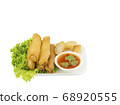 Fried spring rolls with lettuce and dipping sauce on a white plate. Selective focus. 68920555