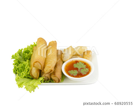 Fried spring rolls with lettuce and dipping sauce on a white plate. Selective focus. Fried spring rolls with lettuce and dipping sauce on a white plate. Selective focus. 68920555