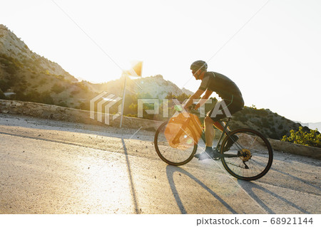 Cycling sport athlete man riding on coastal road Cycling sport athlete man riding on coastal road 68921144