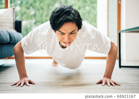 A man doing muscle training at home A man doing muscle training at home 68921167