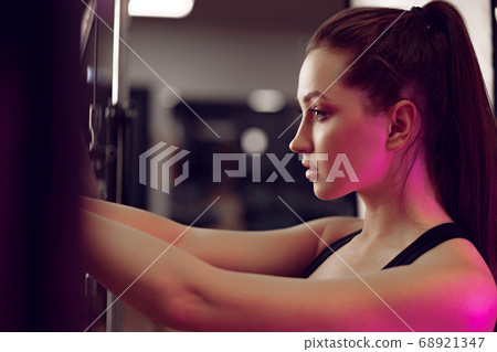 Portrait of a young sporty caucasian woman training in a fitness club Portrait of a young sporty caucasian woman training in a fitness club 68921347
