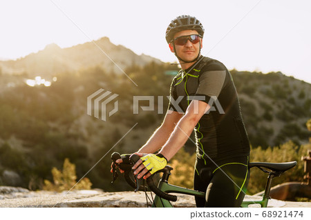 Portrait of male caucasian cyclist with helmet and glasses Portrait of male caucasian cyclist with helmet and glasses 68921474