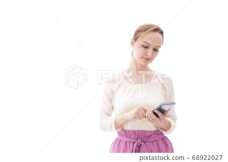 A smiling young woman using a smartphone app A smiling young woman using a smartphone app 68922027