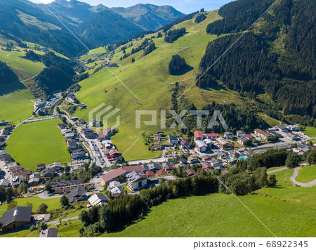 Aerial view of Hinterglemm village and mountains with skiing lifts in Saalbach-Hinterglemm skiing region in Austria on a beautiful summer day Aerial view of Hinterglemm village and mountains with skiing lifts in Saalbach-Hinterglemm skiing region in Austria on a beautiful summer day 68922345