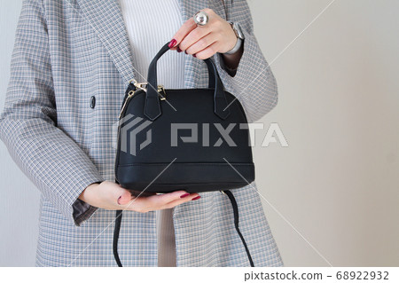 Fashionable woman holding black leather bag Fashionable woman holding black leather bag 68922932